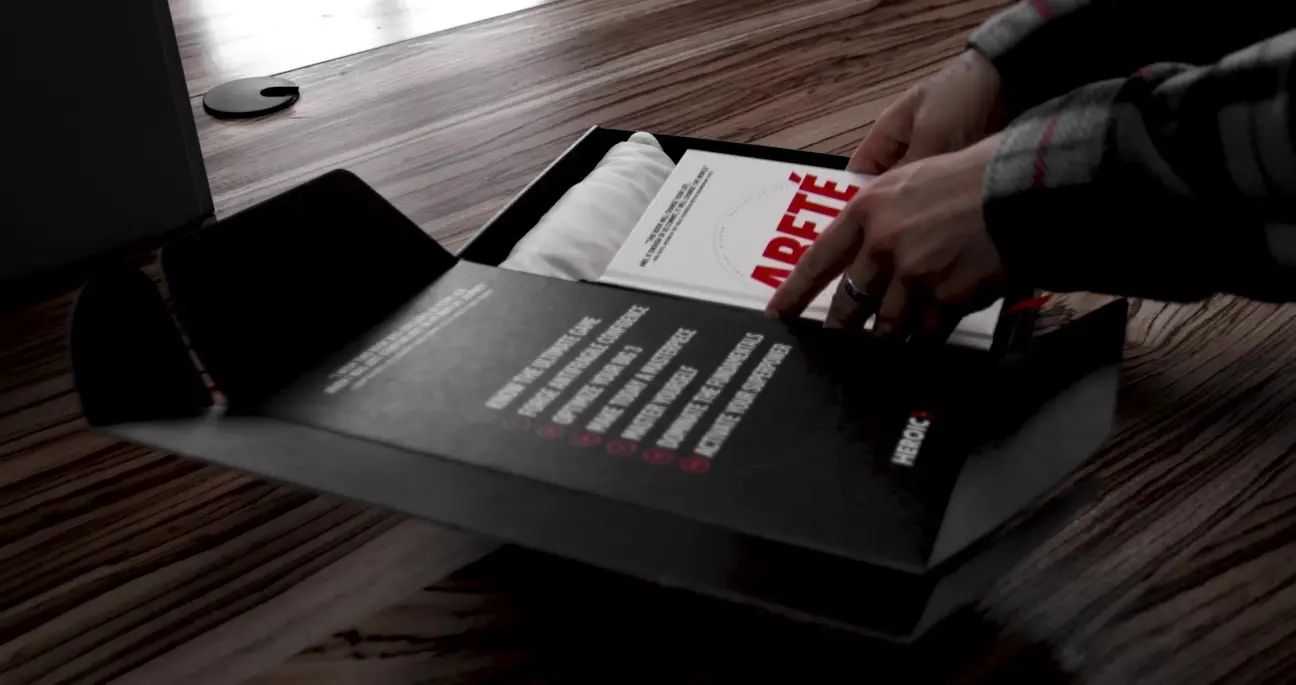 A copy of Areté being lifted out of its box