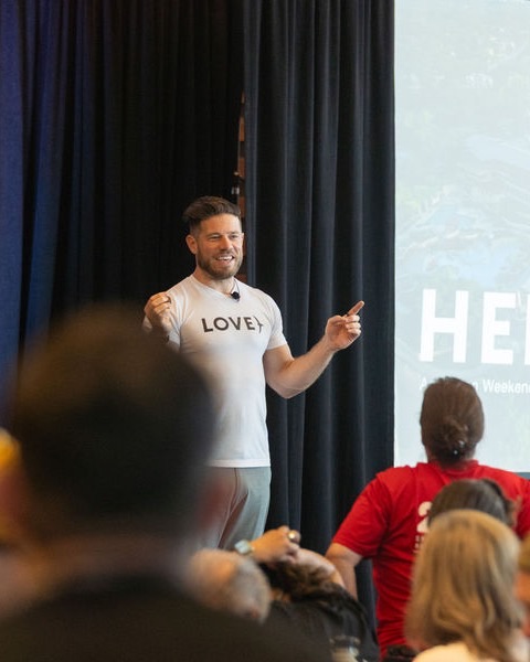 Michael Balchan speaking to a room of members at a Heroic live event