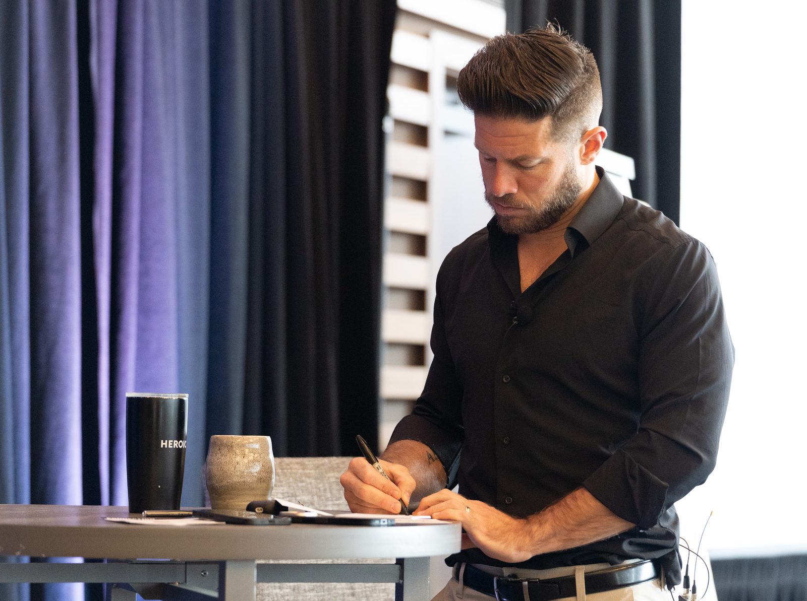 A Heroic coach preparing notes at a corporate workshop